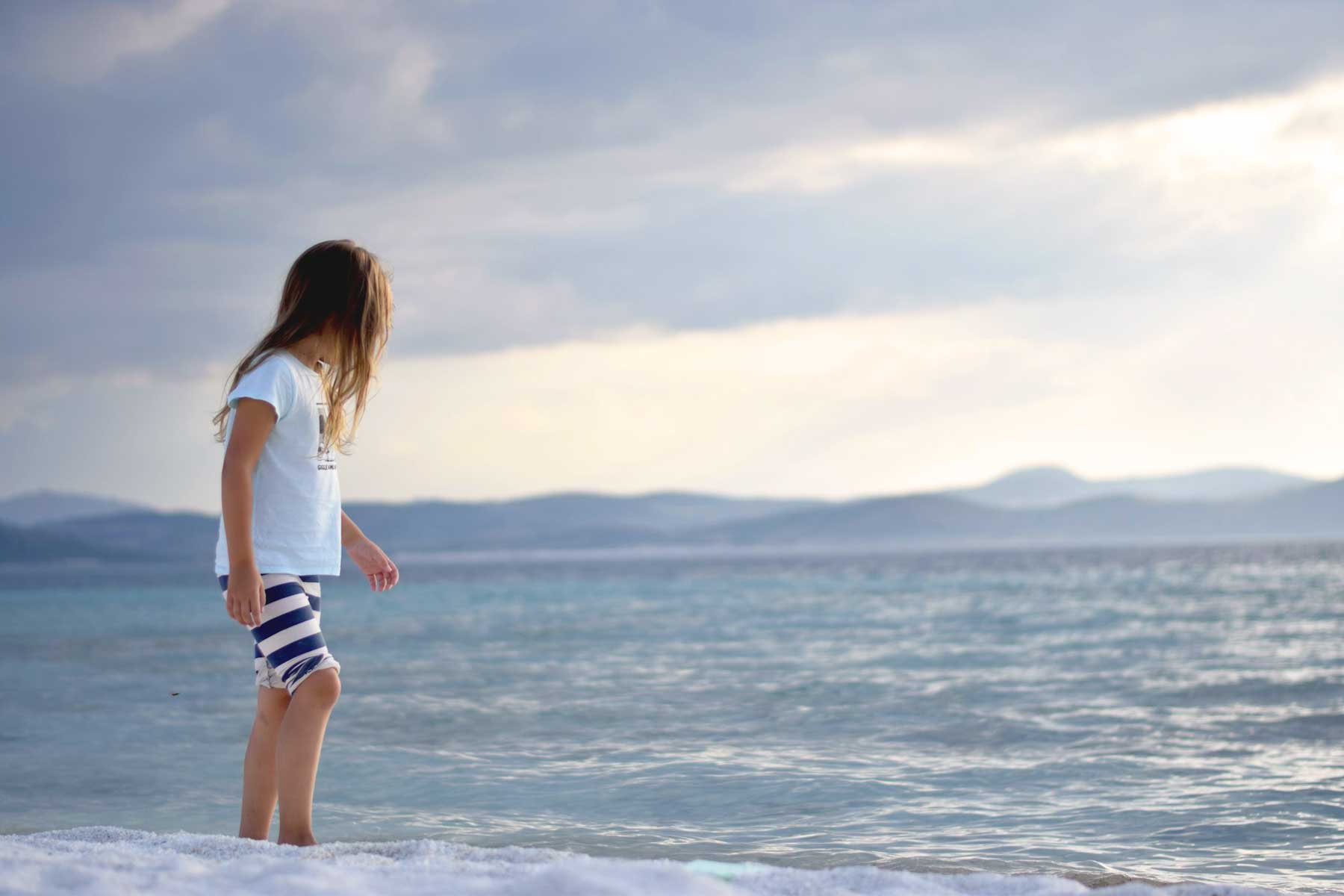 Traumasensible Beratung für Kinder in Dresden – Hoffnung und Stärke finden Mädchen steht am Strand und schaut ins Meer – Symbol für Orientierung und innere Ruhe in schwierigen Zeiten